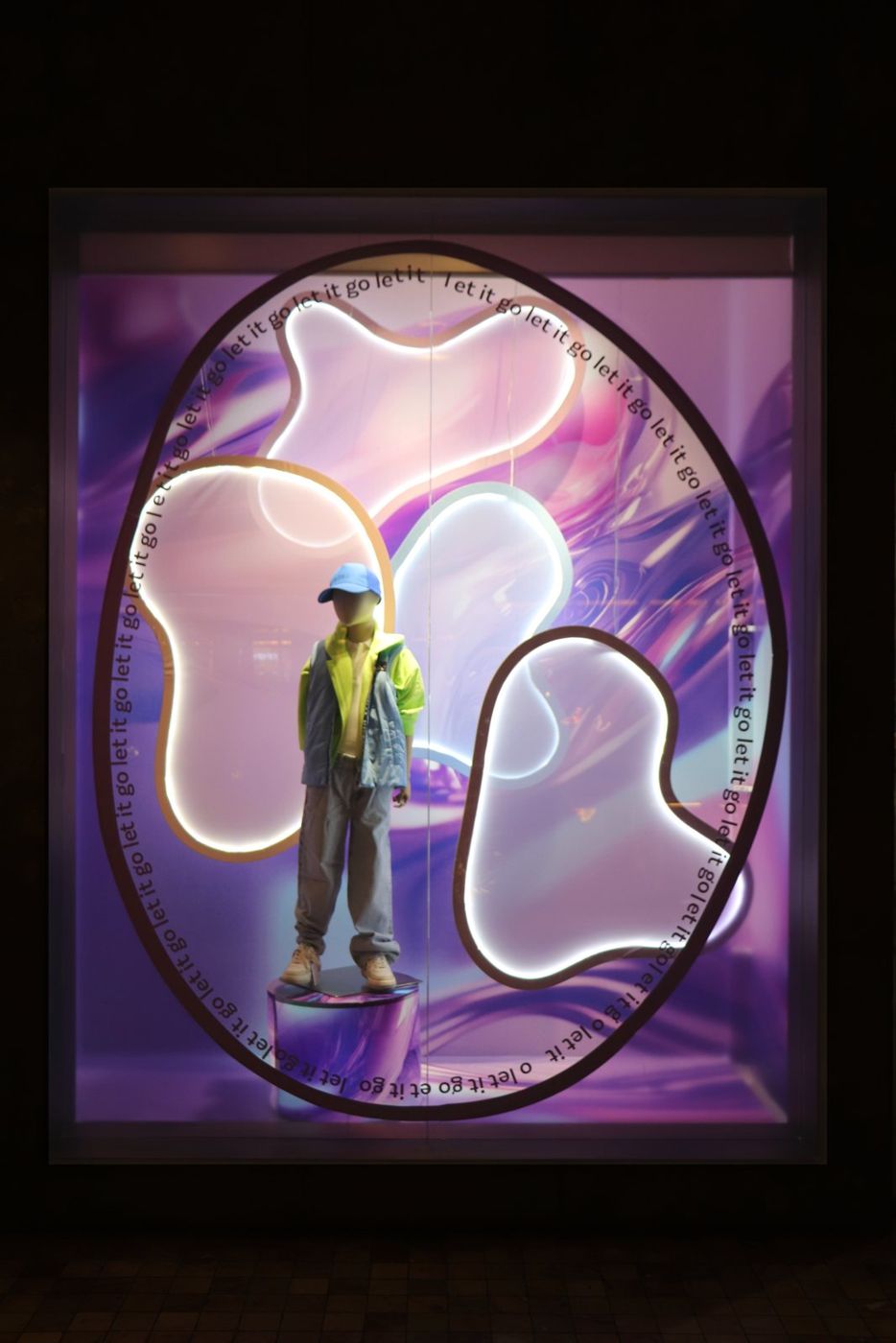 Neon blob shapes framing a mannequin
