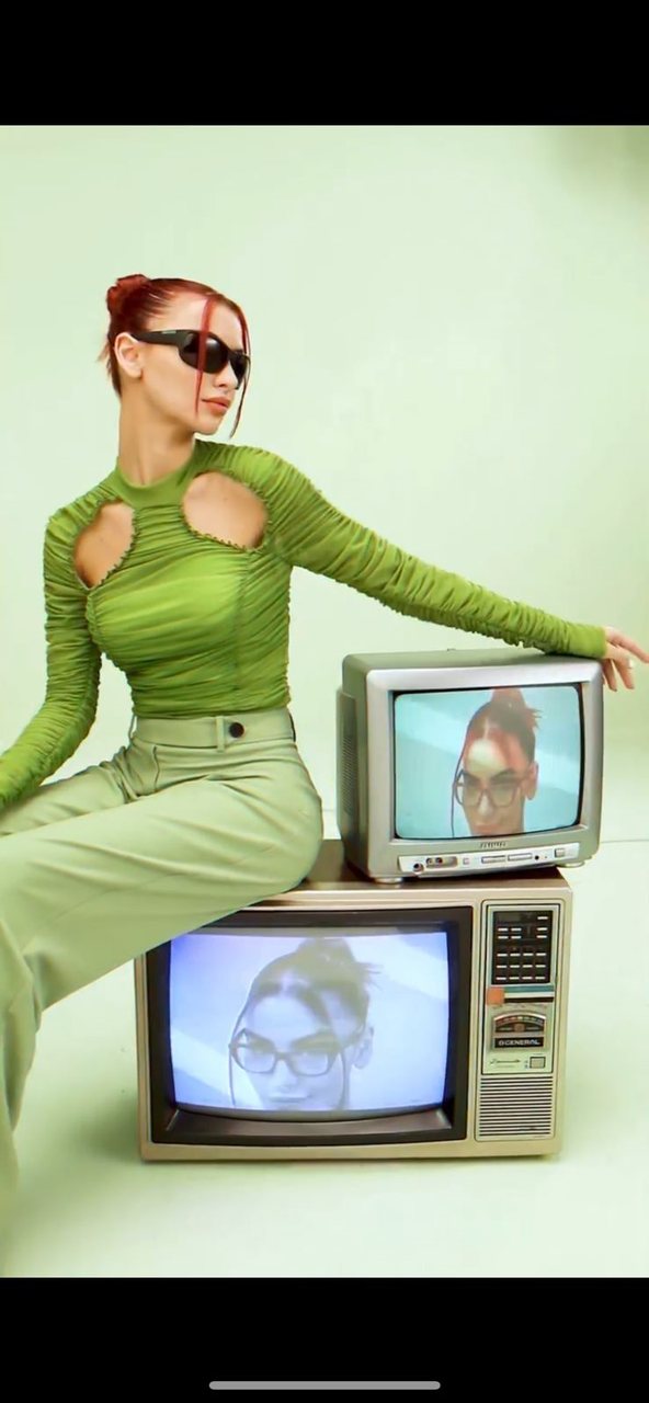 Model in green with retro televisions