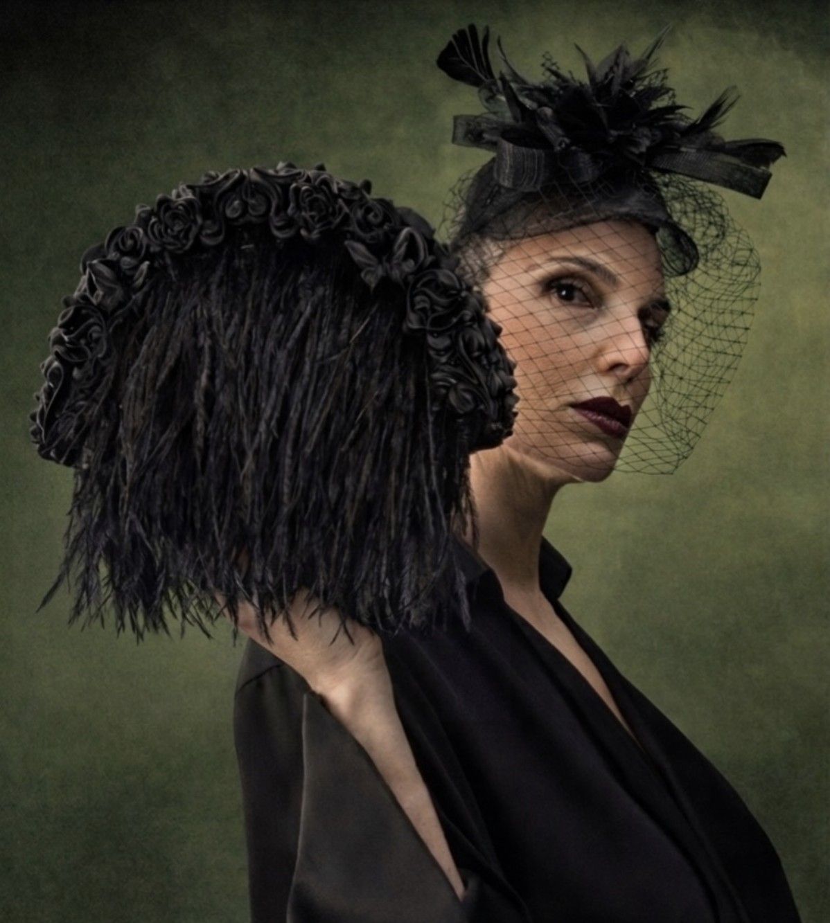 Muse in a veiled headpiece with a feathered bag