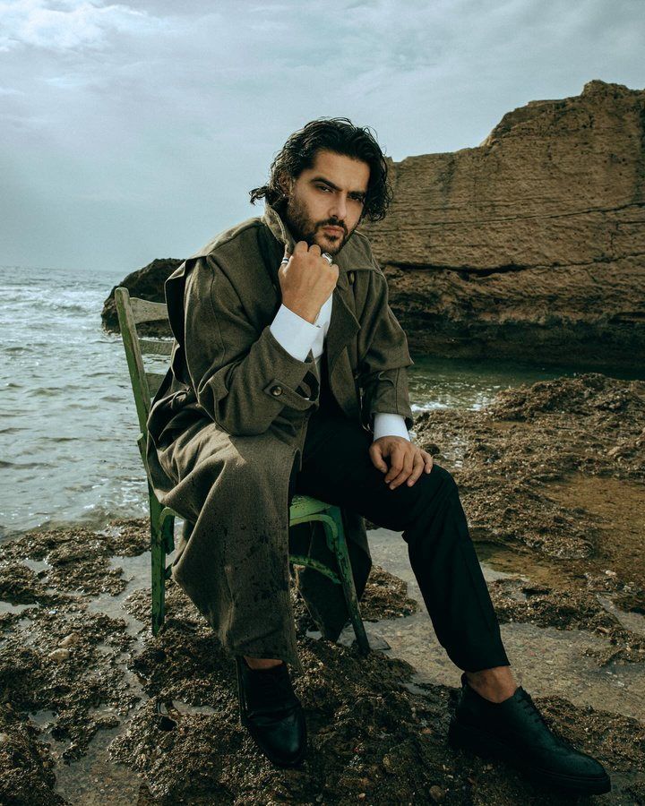 Artist seated on rocks by the sea