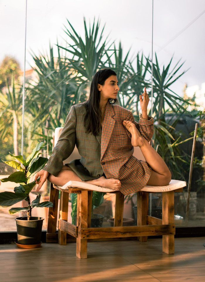 Yoga pose on a wooden chair among plants