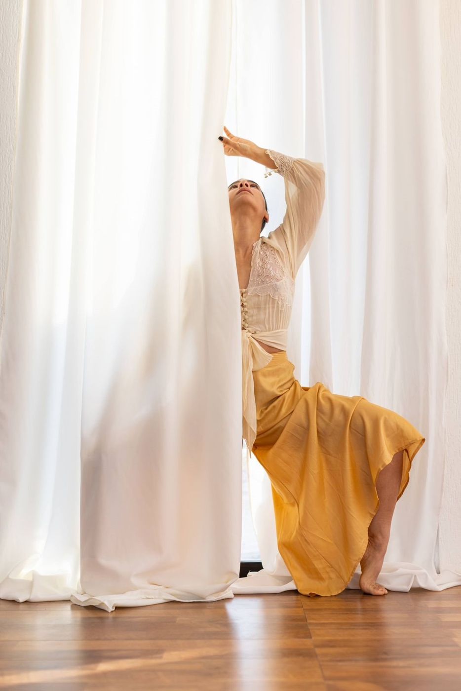 Dancer between white curtains